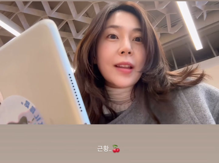 演员白珍熙身穿灰色大衣在图书馆对镜头微笑的近况自拍