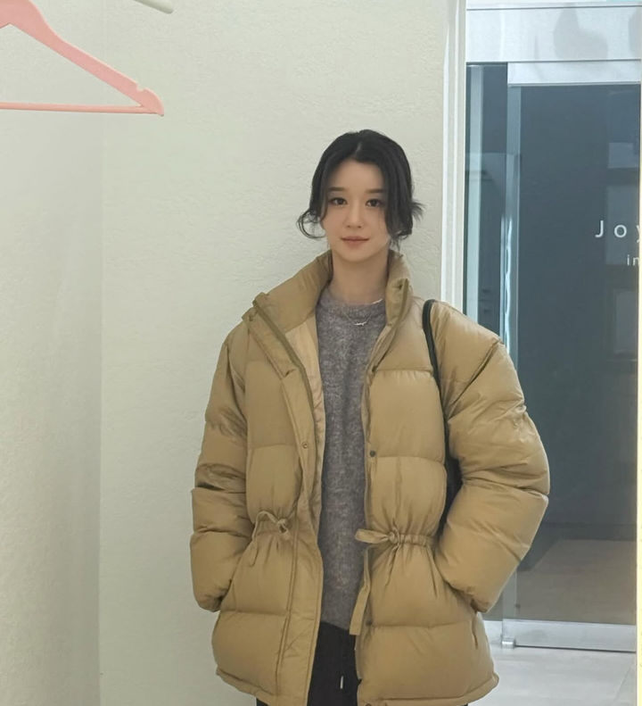 徐睿知在社交媒体晒出身穿羽绒服的冬季近照,盘发造型与微笑营造温暖氛围