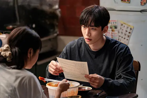 Netflix韩剧《캐셔로》剧照:李准浩饰演小人物英雄尚雄,在便利店收银台前神情坚定
