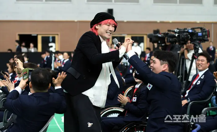 金长勋在韩国残疾人体育会活动上登台演出，现场为运动员们献唱助阵