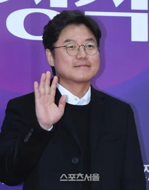 旗安84在海边背景下显得轻松自然,暗示他在Netflix新节目《大焕张基安庄》第二季中的民宿经营与艺术探索。