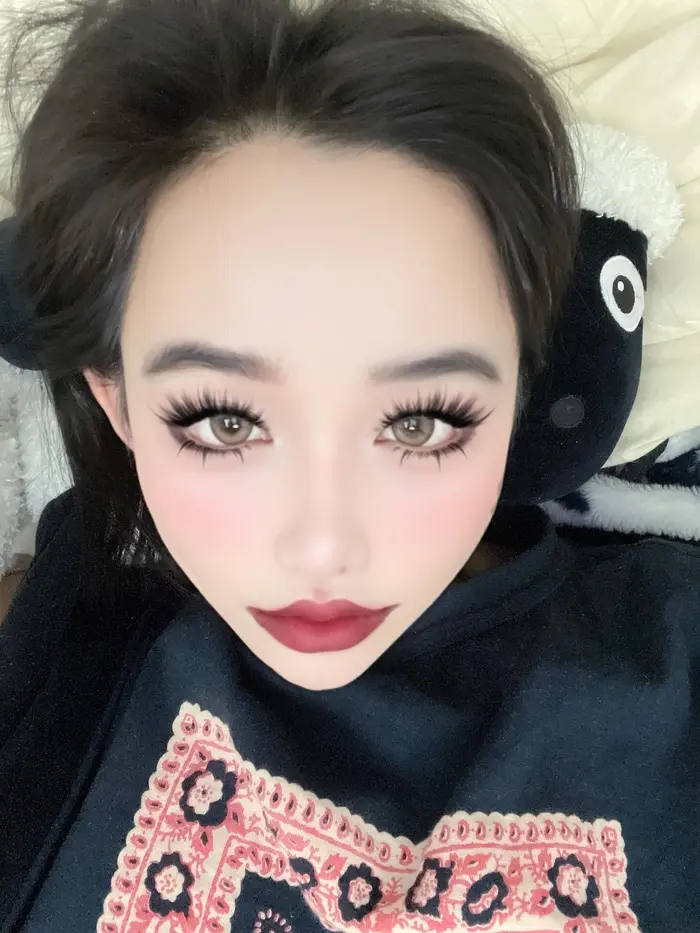 朴春手持香奈儿口红自拍，展示精致洋娃娃眼妆与红唇造型