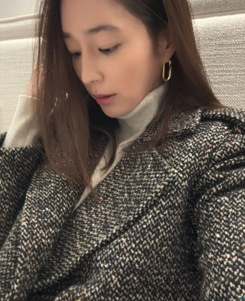 李珉廷身穿深色高领毛衣搭配厚实外套，佩戴金色耳环展现优雅侧颜，在寒冷天气中展示时尚穿搭