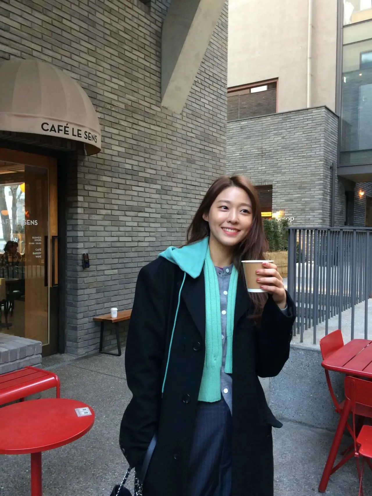 演员雪炫身穿深色长款大衣,尽显高挑身材与优雅气质