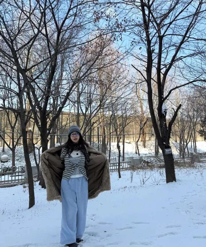 黄薪惠身穿时尚休闲冬装在雪地里开怀大笑,展示63岁的年轻状态