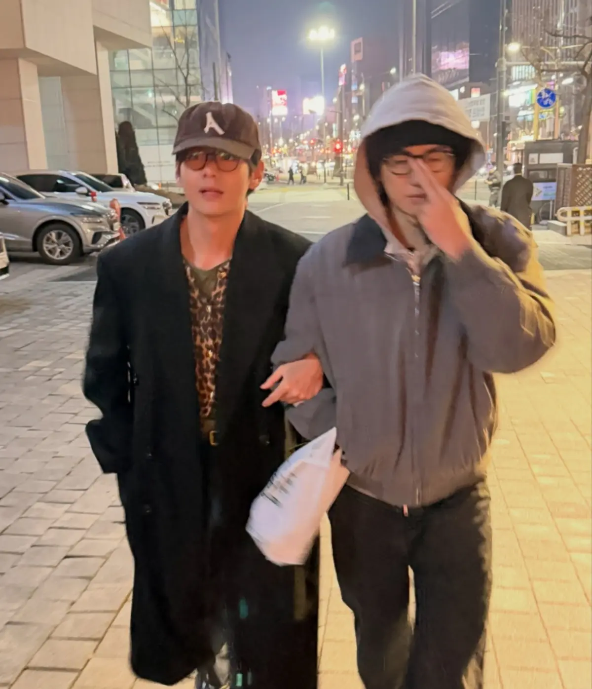 金泰亨身穿连帽大衣反戴帽子嘴里咬着鲫鱼饼漫步街头