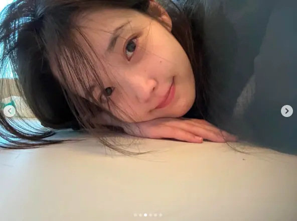 IU李知恩身穿休闲服单手托腮凝视镜头,展现清纯童颜美貌