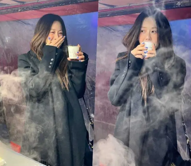 高贤廷身穿黑色大衣在路边摊手持热饮开怀大笑,展现自然冻龄美貌