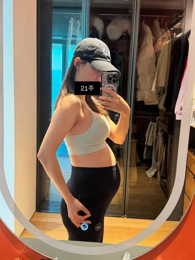 南宝拉身穿瑜伽服在衣帽间对着镜子自拍，展示怀孕21周的明显孕肚，四肢依然纤细