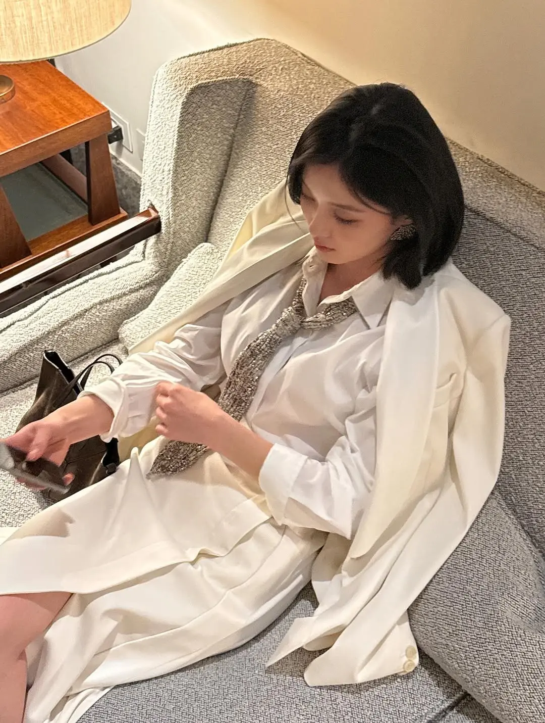 金裕贞佩戴银色领带的特写细节,为白色衬衫增添时尚亮点