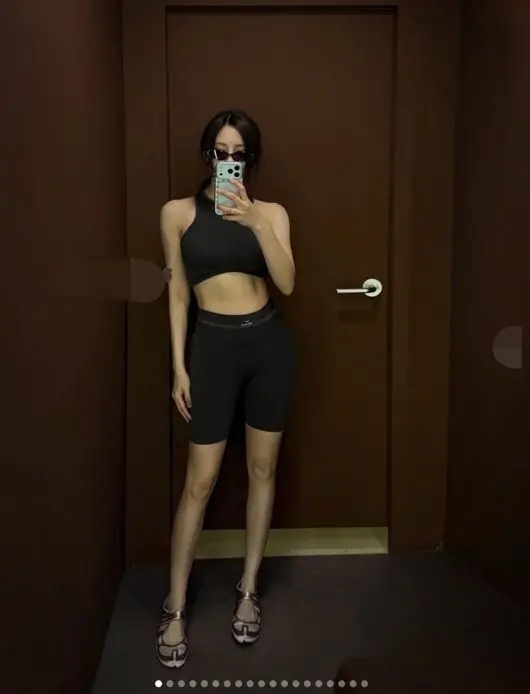孝敏身着粉色运动套装摆出模特姿势,S型曲线尽显,展示充满活力的运动时尚感