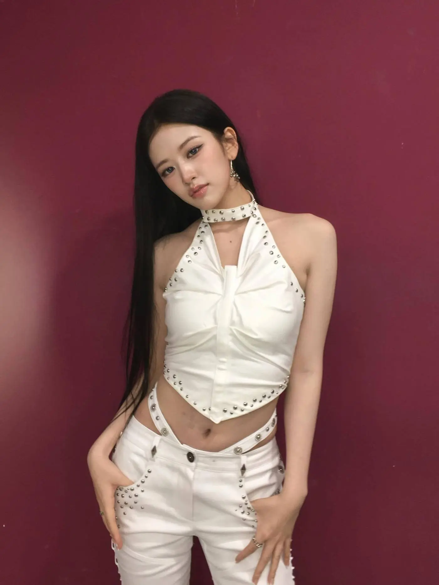 IVE安俞真身穿白色挂脖上衣搭配白裤,摆出高冷姿势展示直角肩线条