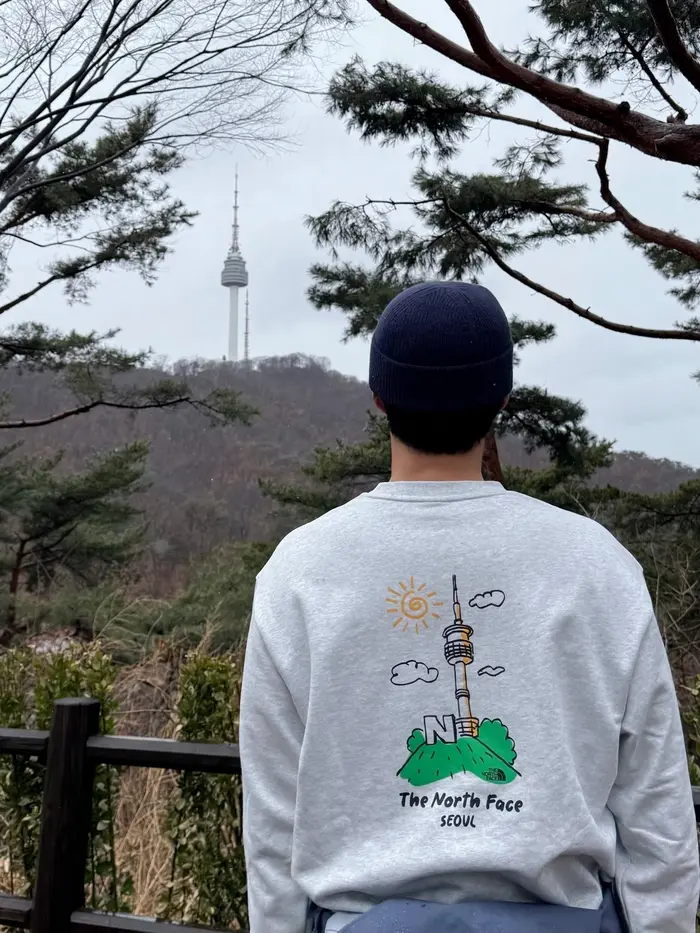 朴宝剑在南山塔背景下的全身照展示山系风格