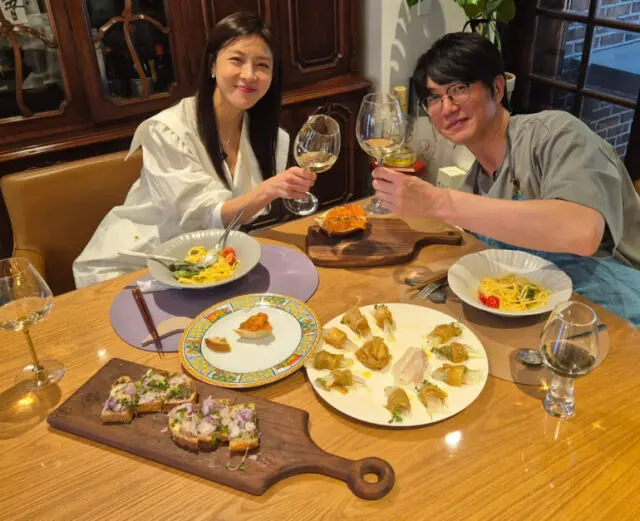 成始璄与河智苑在餐厅享受美食与红酒的温馨合照