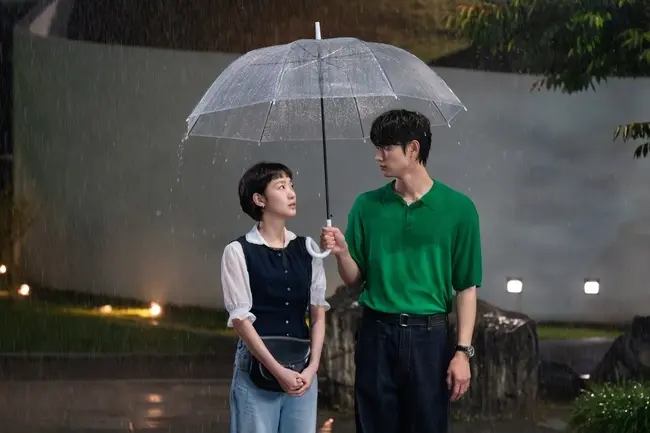 雨中倾斜的雨伞与两人深情对视的浪漫悸动瞬间