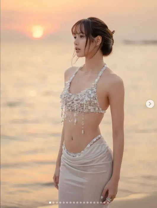 Lisa在绝美海滩晚霞背景下与数字29庆生气球合影，笑容灿烂感染力十足
