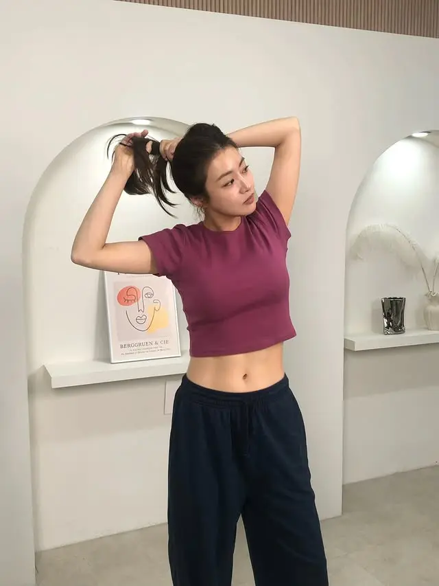 姜素拉身穿短款T恤搭配运动裤,大方展现产后恢复的平坦小腹与11字腹肌。