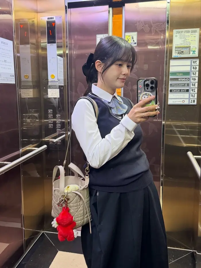 韩国女演员南宝拉孕晚期身穿海军蓝马甲与白衬衫的高中校服造型