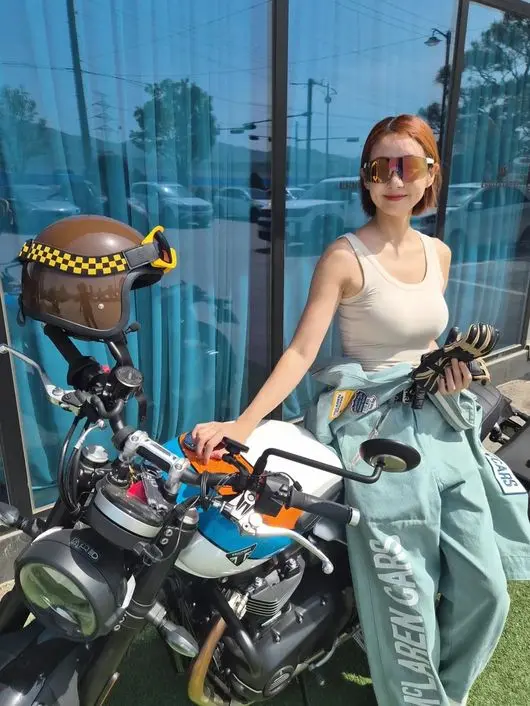 韩国女星吴静妍身穿机车连体裤倚靠在凯旋摩托车旁展现傲人好身材